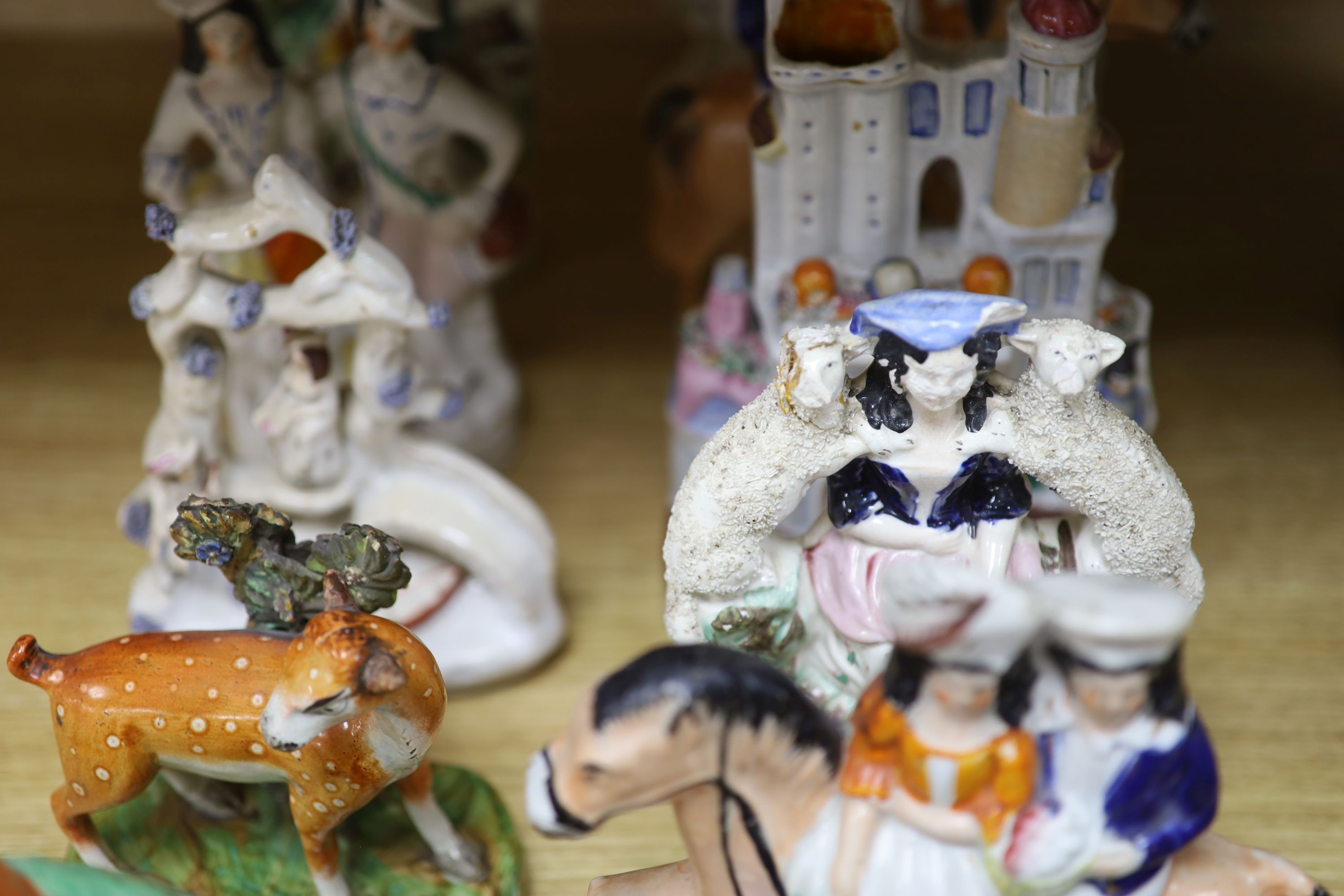 A collection of 19th century Staffordshire flatbacks, including an early 19th century Staffordshire pearlware deer, tallest 33cm